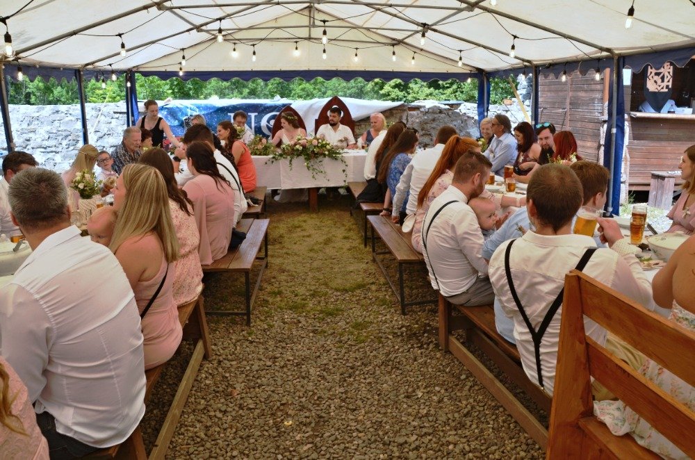 Svatební hostina pod stanem se světýlky na hradním nádvoří